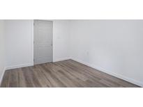 Bright, clean basement room with gray vinyl flooring and a light gray door at 1685 Harbin Sw Rd, Atlanta, GA 30311