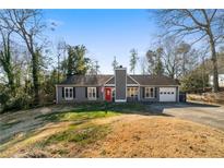 Gray house with red door, attached garage, and landscaping at 113 Hillmont Dr, Woodstock, GA 30188