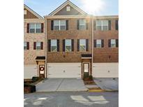 Brick townhome with 2-car garage and front landscaping at 2397 Foley Park St, Snellville, GA 30078