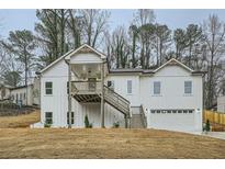 Charming two-story home with board and batten siding, a covered porch, and an attached garage at 4322 Timberland Sw Dr, Lilburn, GA 30047