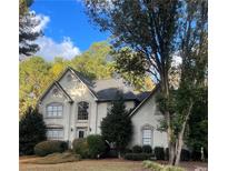 Two-story house with stucco siding, landscaping, and a tree-lined yard at 2080 Milfield Cir, Snellville, GA 30078