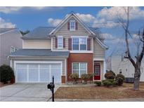 Two-story house with a brick and siding exterior, three-car garage, and landscaping at 3335 Briaroak Dr, Duluth, GA 30096