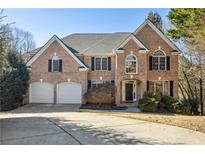 Brick two-story house with a three-car garage and manicured lawn at 6820 Milbury Ct, Alpharetta, GA 30005