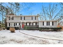 Two-story house with gray siding, red door, and a snow-covered yard at 4071 Williamsburg Dr, Atlanta, GA 30337