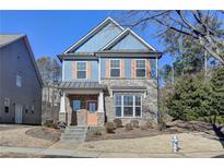 Two-story house with blue siding, brick accents, and a peach-colored door at 2329 Village Grove Dr, Suwanee, GA 30024