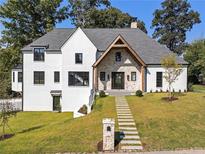 Two-story white house with gray roof, stone accents, and landscaped lawn at 464 Pine Tree Ne Dr, Atlanta, GA 30305