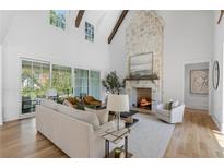 Bright and airy living room with soaring ceilings, stone fireplace, and sliding glass doors to the backyard at 464 Pine Tree Ne Dr, Atlanta, GA 30305