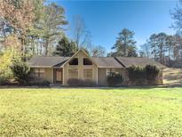 Ranch style house with a large front yard and mature trees at 3096 Village Glen Trl, Snellville, GA 30039