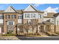 Brick front elevation of charming townhome with gray siding and landscaping at 132 Marietta Walk Trce, Marietta, GA 30064