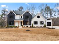 Two-story farmhouse-style home with white and black exterior, and landscaping at 208 Pindos Sw Pl, Powder Springs, GA 30127