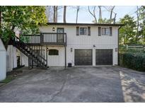 White house with dark garage doors, deck, and stairs at 2671 Caldwell Ne Rd, Brookhaven, GA 30319