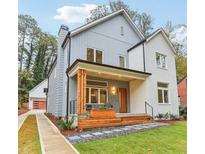 Two-story modern farmhouse with gray and white siding, a covered porch, and landscaped yard at 1356 Deerwood Dr, Decatur, GA 30030