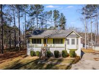 Ranch style home with front porch and deck, nestled in a wooded setting at 1094 Plantation Ct, Villa Rica, GA 30180