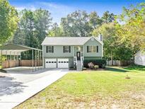 Charming ranch home with carport, landscaped lawn, and two-car garage at 456 Pine Shadows Dr, Dallas, GA 30157
