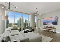 Spacious living room with city views, hardwood floors, and modern furniture at 1080 Peachtree Ne St # 1402, Atlanta, GA 30309