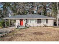 Ranch style home with red door, landscaping, and mature trees at 2681 Plantation Dr, Atlanta, GA 30344