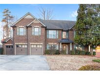 Brick two-story home with three car garage and landscaped yard at 4660 Lake Hill Trl, Ellenwood, GA 30294