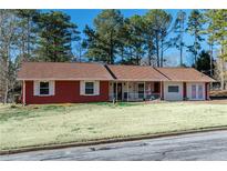 Ranch style brick home with a spacious front yard and mature trees at 1830 Brandy Se Ln, Conyers, GA 30013