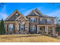 Brick and stone two-story home with a front porch and landscaping at 2082 Greenway Mill Ct, Snellville, GA 30078