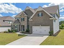 Stunning two-story brick home with a two-car garage, well-manicured lawn, and walkway to the front door at 4259 Hansford Loop, Marietta, GA 30064