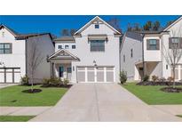 Two-story home with gray siding, two-car garage, and landscaping at 3576 Cavell Ct, Auburn, GA 30011