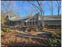 Gray house with large windows, deck, and stone walkway, nestled in a wooded area at 190 Valley Cv, Atlanta, GA 30350