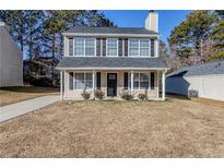 Two-story house with gray roof, beige siding, and black shutters at 7618 Mcgillicuty Dr, Union City, GA 30291