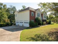 Two-story house with a three-car garage and landscaped yard at 4171 High Country Dr, Douglasville, GA 30135