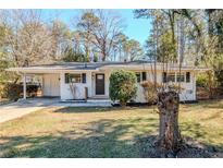 Charming ranch home with a well-manicured lawn and mature trees at 2756 Plantation Dr, East Point, GA 30344