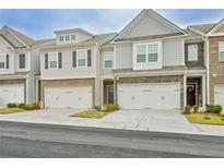 Gray townhome exterior with two-car garage and landscaping at 7628 Squire Ct, Fairburn, GA 30213
