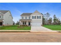 Two-story house with light beige siding, dark shutters, and a two-car garage at 576 Teversham Dr, Mcdonough, GA 30253
