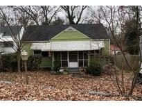 Light green house with a screened porch and mature trees at 909 Margaret Nw Pl, Atlanta, GA 30318