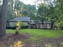Brick ranch home with mature trees and a large lawn at 8374 Carlton Rd, Riverdale, GA 30296