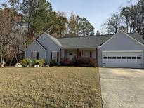 Gray house with brown accents, attached garage, and manicured lawn at 526 Bluff Ct, Woodstock, GA 30188