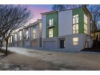 Contemporary townhome with a two-car garage and a vibrant green and white exterior at 1412 Peter Haughton Nw Way, Atlanta, GA 30318