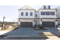 White brick townhome with 2-car garage, landscaping, and modern design at 712 Dodd Ln # 154, Buford, GA 30518
