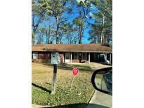 Ranch home with a red exterior, visible mailbox and landscaping at 1779 Big Horn Se Ct, Conyers, GA 30013