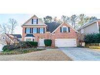 Brick two-story house with a white door and two-car garage at 5274 Monarch Pine Ln, Peachtree Corners, GA 30071