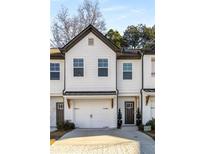 Two-story townhome with white exterior, gray accents, and a two-car garage at 4197 Spring Valley Cir, Tucker, GA 30084