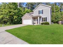 Two-story house with gray siding, stone accents, and a spacious lawn at 7977 Rudder Cir, Fairburn, GA 30213