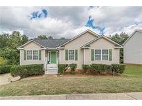 Ranch style home with green accents and landscaped yard at 121 Millwheel Dr, Villa Rica, GA 30180