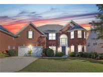 Brick two-story home with a three-car garage and landscaped yard at 575 Maple Crest Dr, Lawrenceville, GA 30044