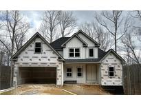 A new two-story home shows modern vertical siding, dark roof, and an attached two-car garage at 321 Evie Ln, Canton, GA 30115