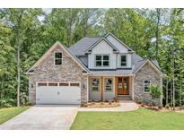 Charming new two-story home features stone accents, white siding, and a well-manicured front lawn at 321 Evie Ln, Canton, GA 30115
