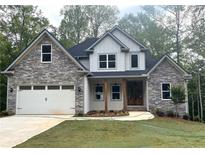 Beautiful two-story home featuring stone and siding, complemented by a manicured lawn and inviting entry at 321 Evie Ln, Canton, GA 30115