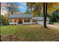 Newly renovated ranch home with white brick exterior, landscaping, and a two-car garage at 1252 Kingsview Se Cir, Smyrna, GA 30080
