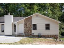 Ranch style home with stone accents and mature trees at 3742 Tree Bark Ln, Snellville, GA 30039