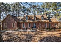 Brick house with dormers, mature trees, and a large yard at 5275 Johnson Spur, Loganville, GA 30052