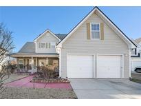 Charming two-story home featuring a two-car garage and covered front porch entrance at 7492 Ferrara Dr, Lithonia, GA 30058