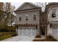 Brick front exterior of a two-story townhome with a two-car garage and pergola at 131 Wards Crossing Way # 19, Johns Creek, GA 30022